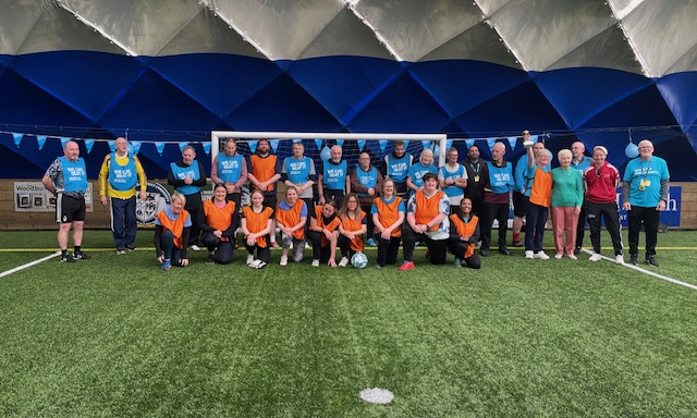 Walking Football 2026 Two teams of a walking football match posing in front of the goal